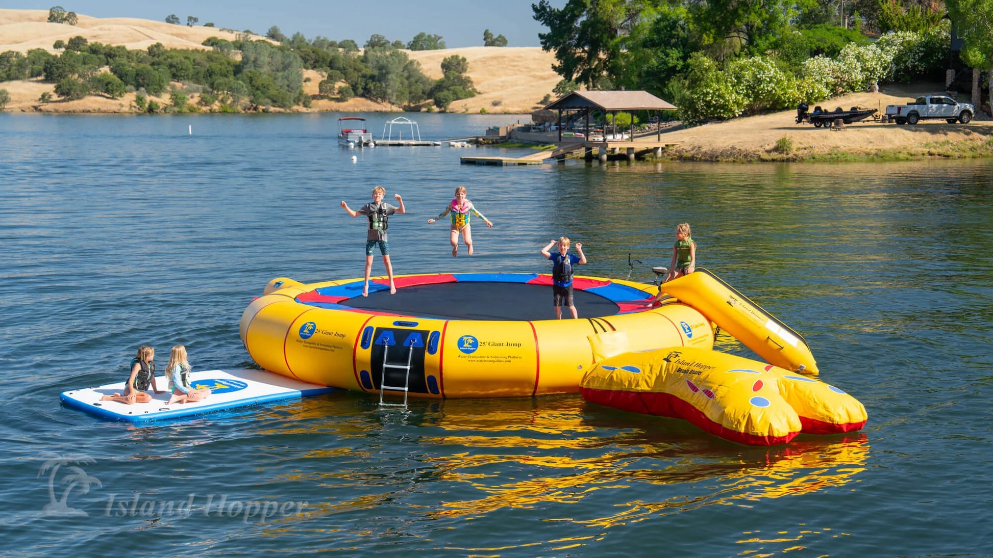 Island Hopper 25ft Giant Jump yellow water park floating lake trampoline with two boarding areas fully assembled in open water 