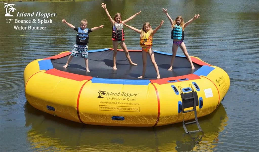 group of four jumping on Island Hopper 17ft inflatable water trampoline water bouncer anchored on a lake