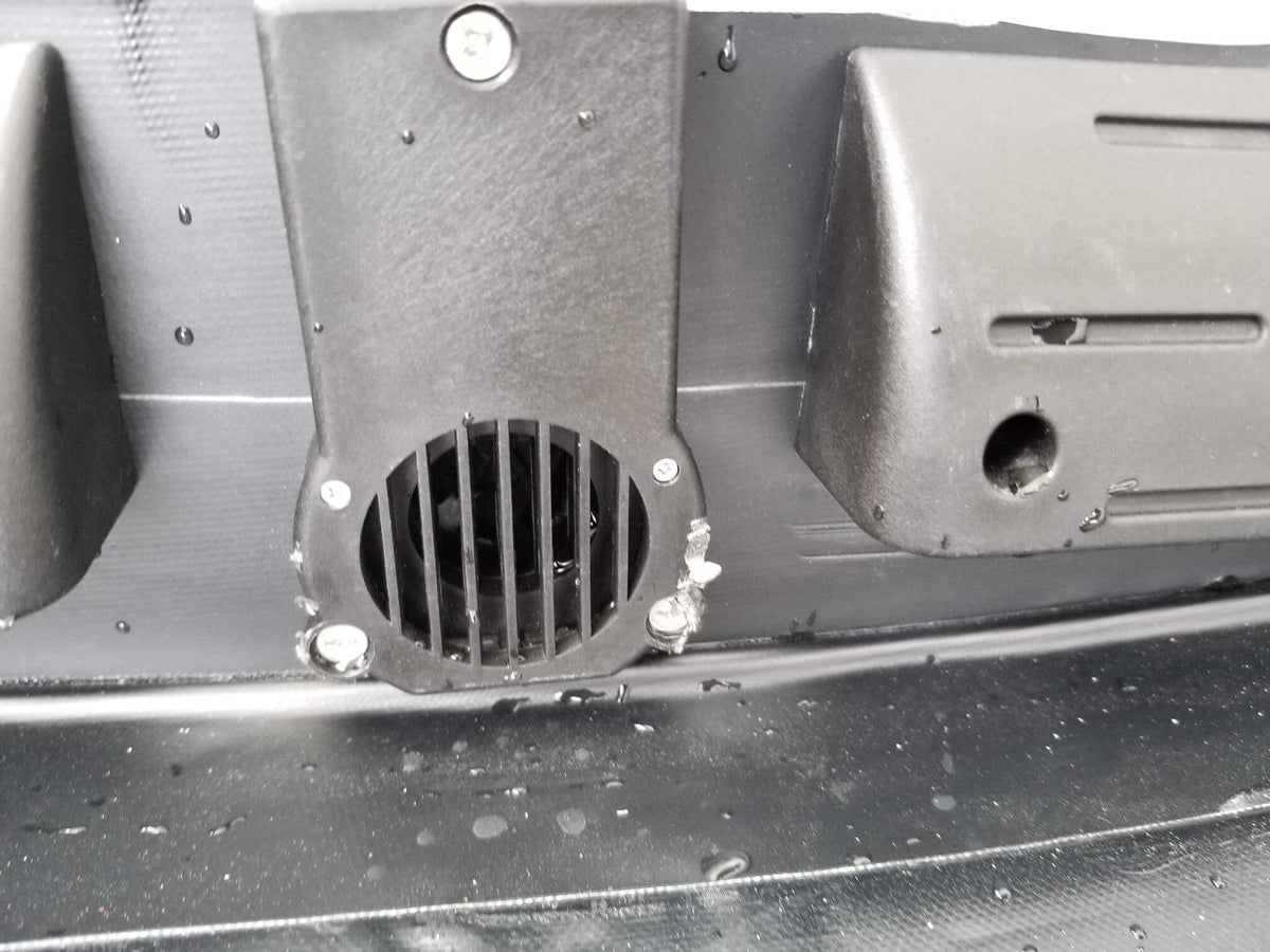 Self-bailing drain valve with grille installed inside an inflatable dinghy transom